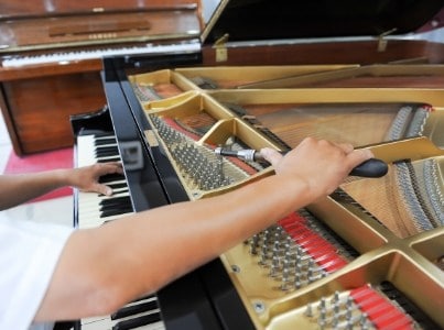 technician tuning piano